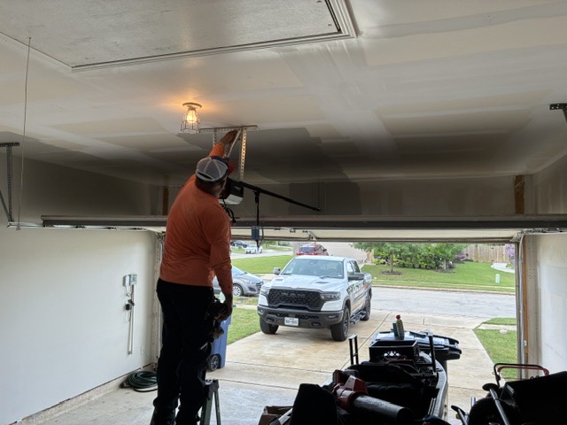 Technician servicing a garage door opener in New Braunfels TX