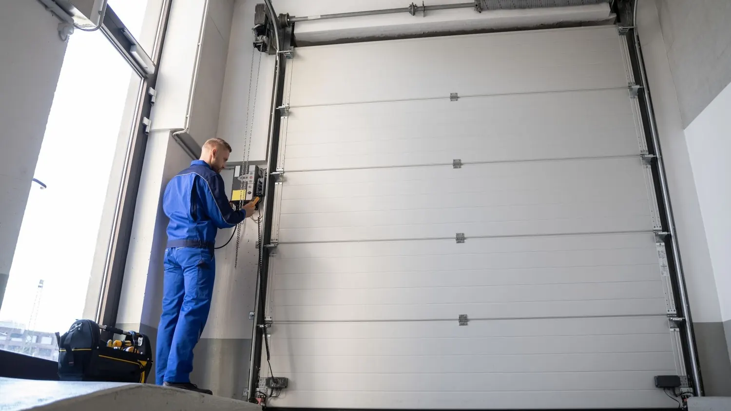 Technician repairing a shop garage door in Spring Branch, TX