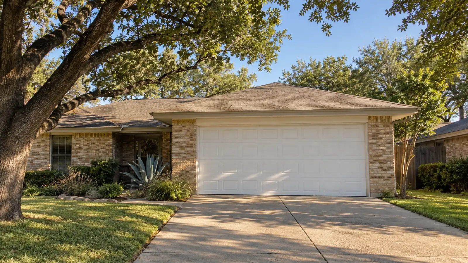 Brick ranch home with a white two-car garage door in South Austin, TX