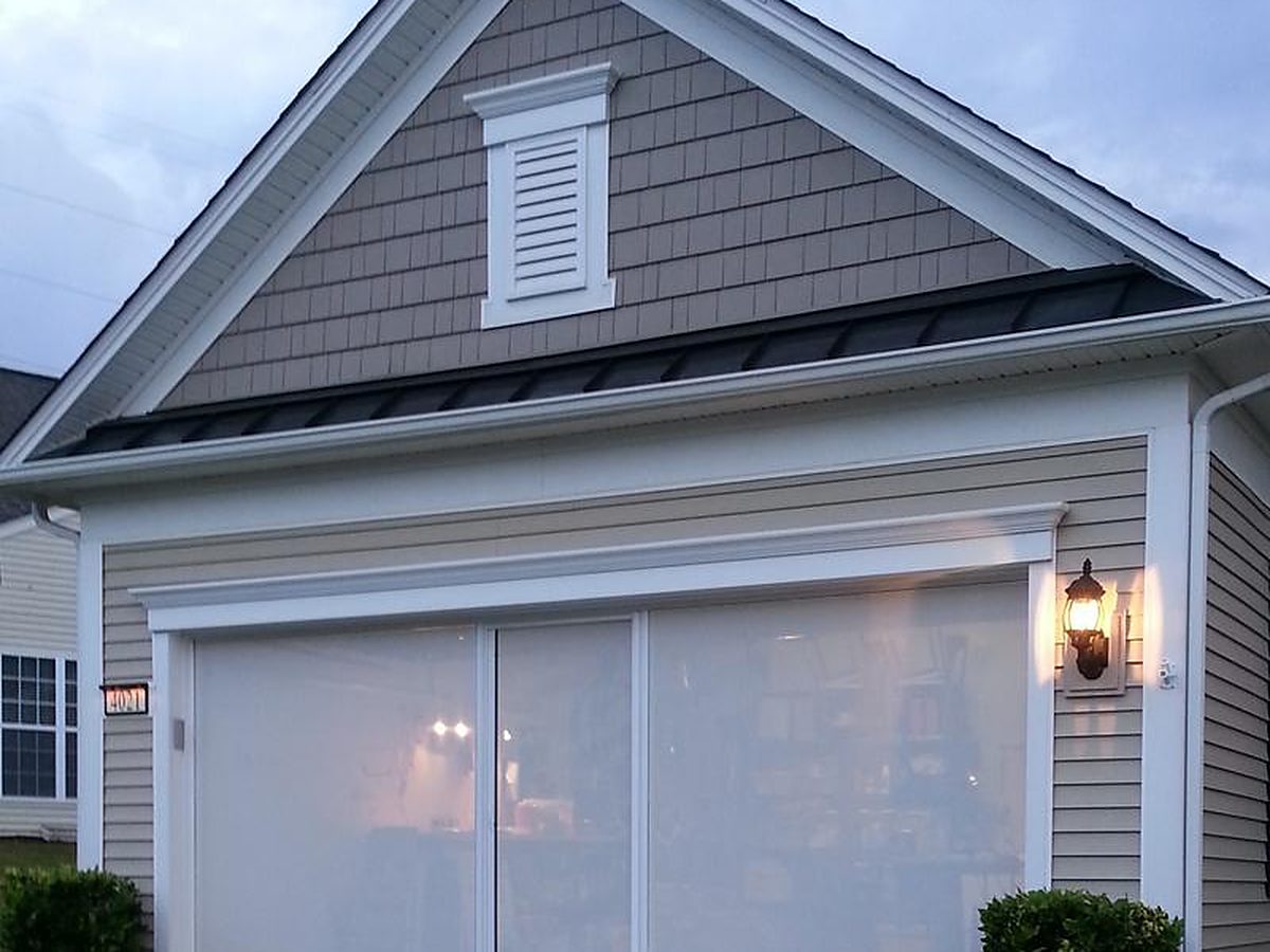 White privacy Lifestyle garage screen glowing at dusk on a gray two-car garage