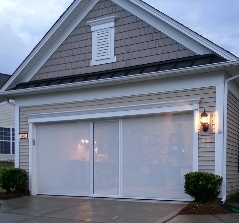 Lifestyle garage screen with white privacy mesh glowing at dusk